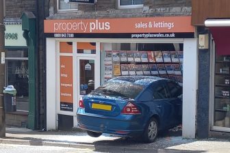 Empty car crashes through estate agency window